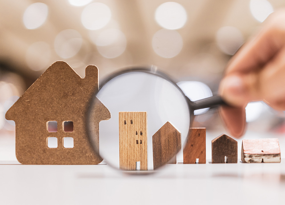 Hand Holding Magnifying Glass And Looking At House Model, House